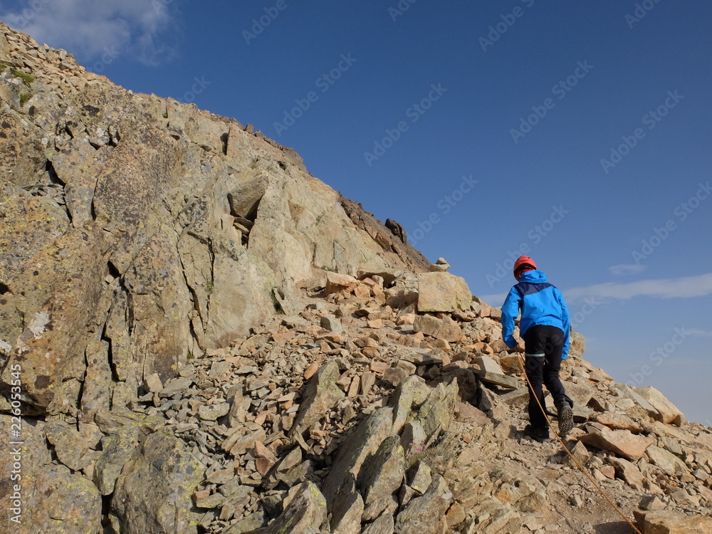 Jeune garçon en alpinisme au  pic d'ossau dans les pyrénées avec casque rouge