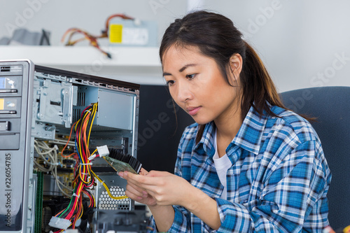Wallpaper Mural female tech tests electronic equipment in service centre Torontodigital.ca