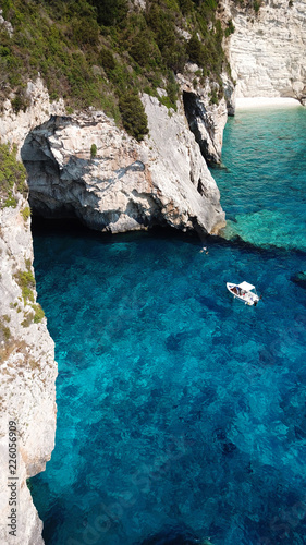 Aerial drone bird's eye view photo of iconic tropical rocky paradise bay called blue lagoon with caves and turquoise clear waters visited by sail boats, island of Paxos, Ionian, Greece