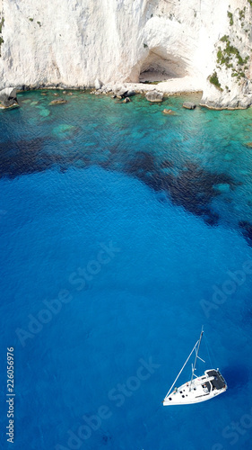 Aerial drone bird s eye view photo of sail boats docked in tropical caribbean paradise bay with white rock caves and turquoise clear sea