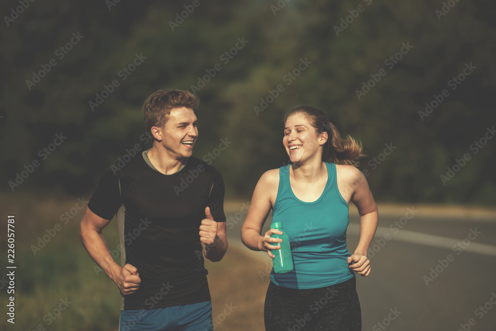 young couple jogging along a country road young couple jogging along a country road