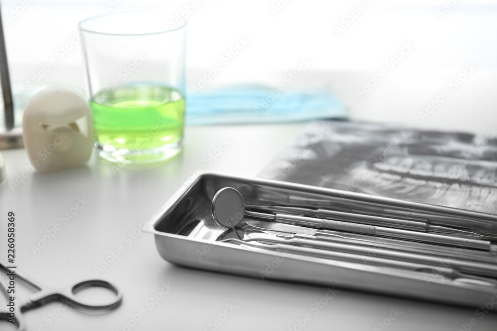 Tray with dentist's tools on light table in doctor's office Tray with dentist's tools on light table in doctor's office