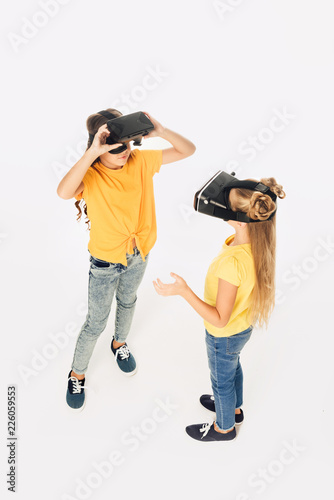 high angle view of beautiful kids using virtual reality headsets isolated on white