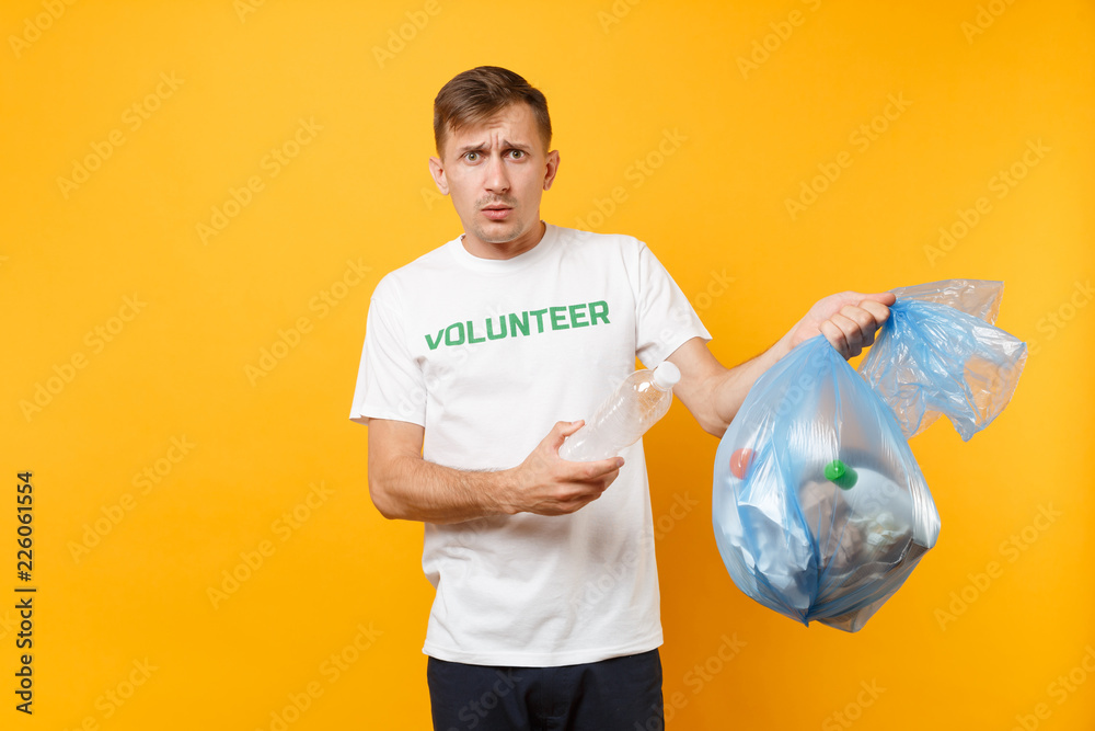 Man in t-shirt volunteer, trash bag isolated on yellow background. Voluntary free assistance help, charity grace. Environmental pollution problem. Stop nature garbage environment protection concept.