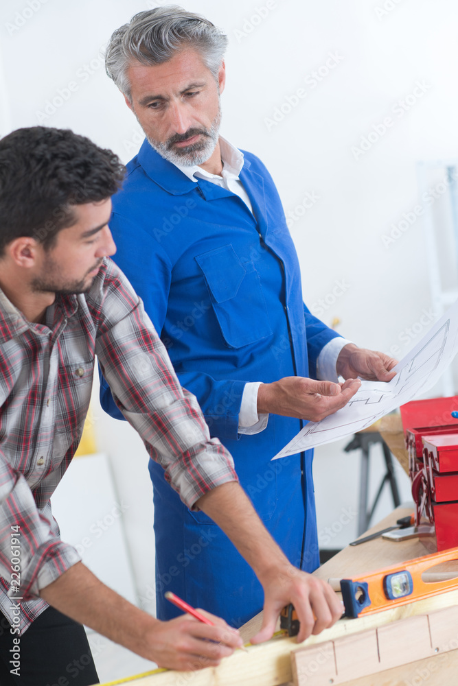 Obraz premium carpentry apprentice getting instructions from the teacher