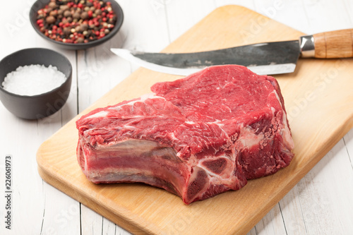 Raw beef meat with bone on cutting board