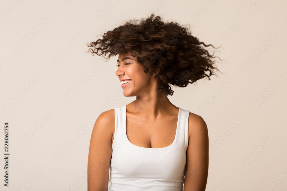 Happy african-american girl playing with her curly hair Happy african-american girl playing with her curly hair