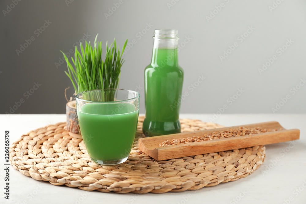 Glassware of healthy juice with sprouted wheat grass and seeds on wicker mat Glassware of healthy juice with sprouted wheat grass and seeds on wicker mat
