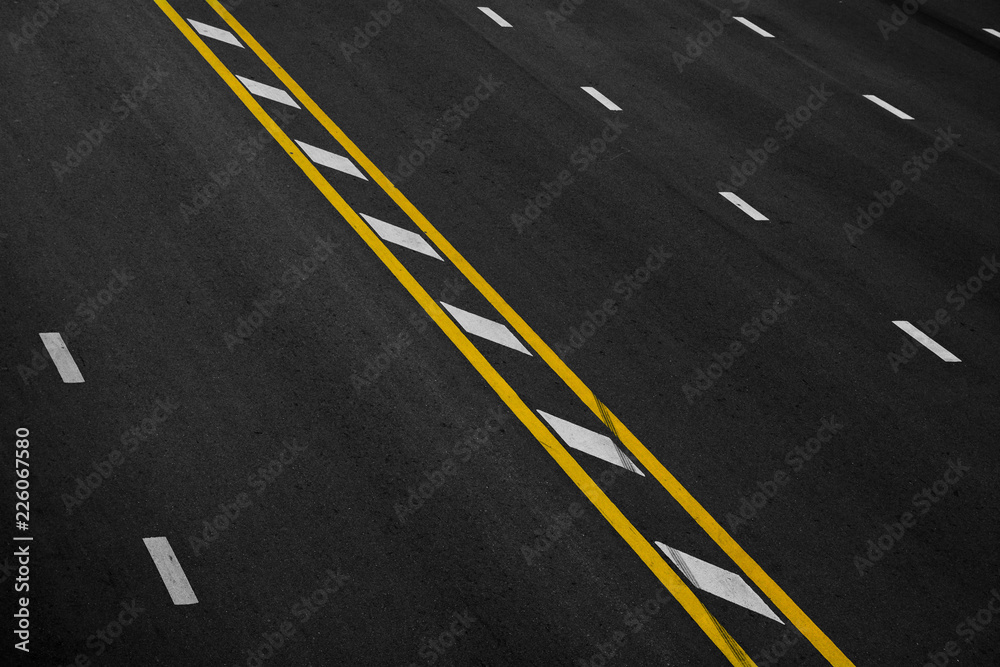 Yellow and white paint line on black asphalt. space transportation background Yellow and white paint line on black asphalt. space transportation background