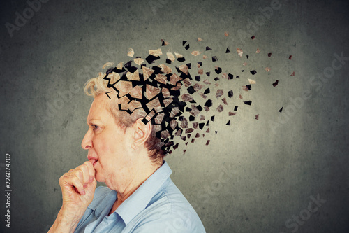 Senior woman losing parts of head feeling confused as symbol of decreased mind function. photo