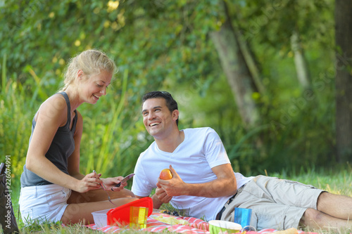 young couple lounging in sunny spring day at picnic outdoors