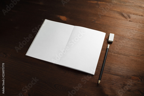 Blank stationery mock up. Brochure, pencil and eraser on wooden background. Template for placing your design.