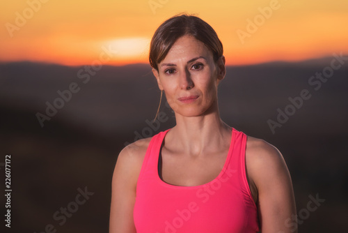 Young beautiful woman portrait in sport clothes at sunset