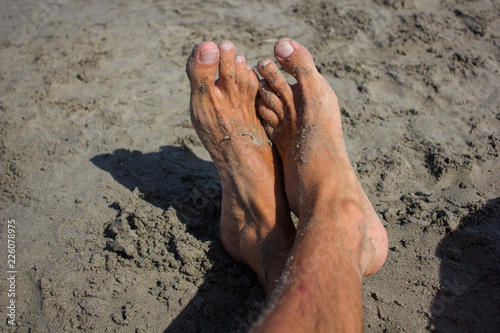 male legs in sand