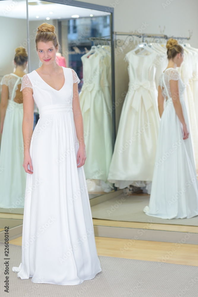 girl standing in the bright studio in a wedding dress girl standing in the bright studio in a wedding dress