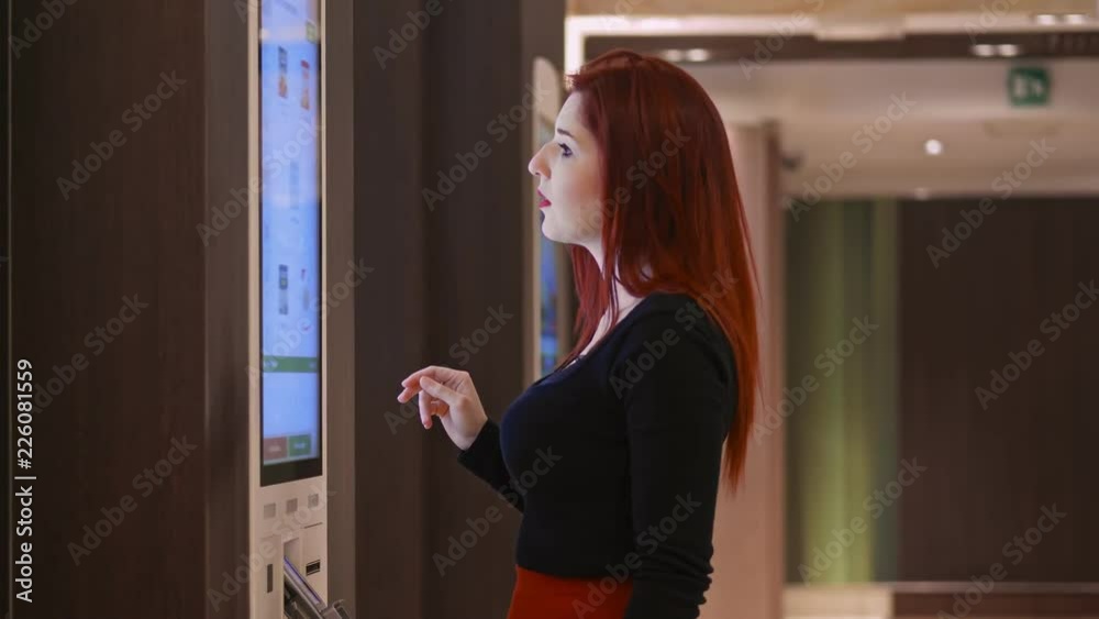 beautiful woman at the vending machine choosing the product to buy beautiful woman at the vending machine choosing the product to buy