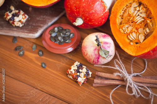  Set of pumpkins, apples and nuts with maple leaves on the wooden background. Autumn mood. Thanksgiving concept. Healthy food, diet, lifestyle and holiday theme. Top view. Close up.
