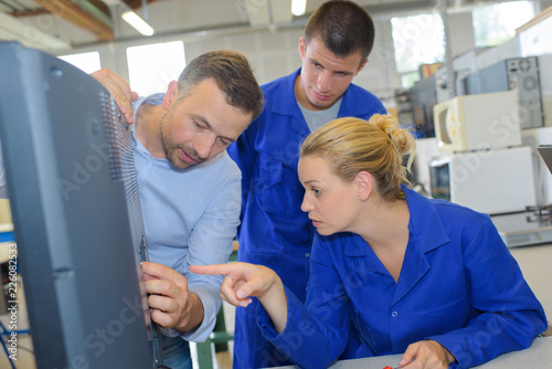 electrician and apprentices fixing television