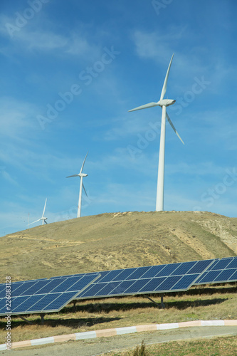 Solar-powered electricity system . Solar panel, photovoltaic, alternative electricity source . Wind farm: Industrial Eolic installation . Alternative energy source from wind power.