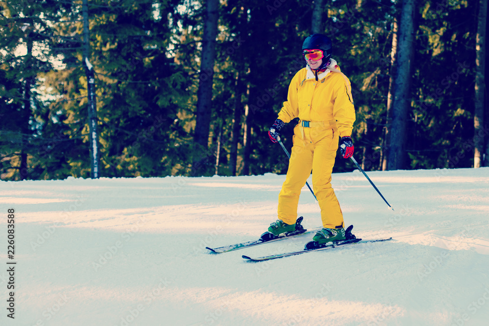 Fototapeta premium Panoramic shot of a female skier resting on top of the mountain observing nature at ski resort on a beautiful sunny winter day copyspace peaceful recreational vacation travel concept