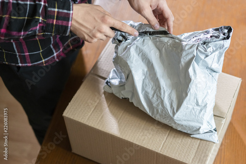 hands using knife to open the delivered package at home f