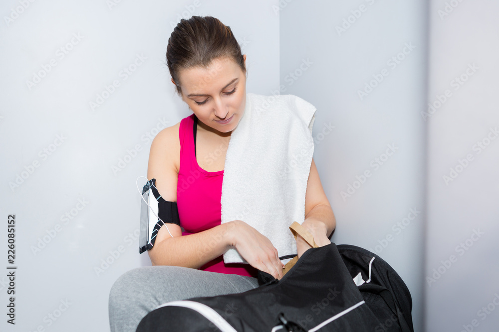 young woman with towel and bottle resting indressing room young woman with towel and bottle resting indressing room