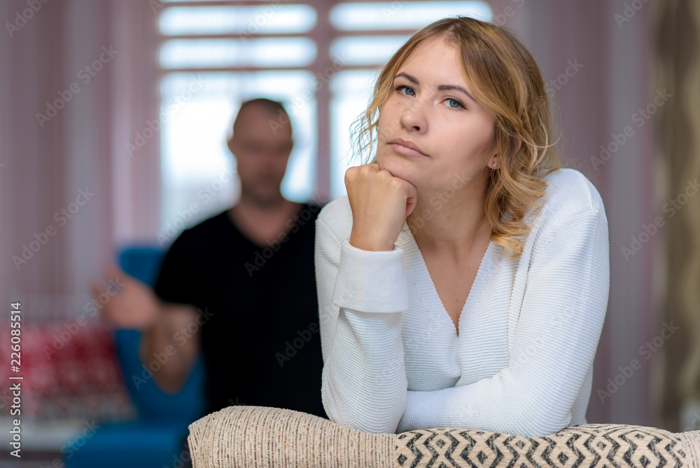 Family problems of the young wife and husband on the sofa in a room. Family problems of the young wife and husband on the sofa in a room.