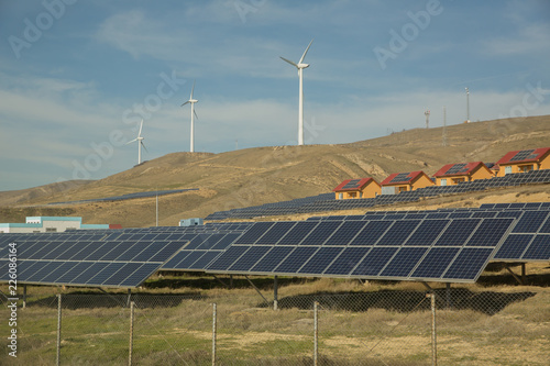 Solar-powered electricity system . Solar panel, photovoltaic, alternative electricity source . Wind farm: Industrial Eolic installation . Alternative energy source from wind power.