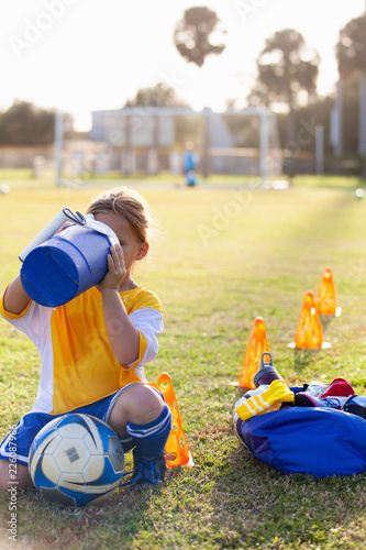 A soccer player takes a break for water. 