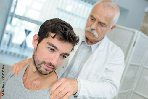 physiotherapist doing shoulder massage to his patient