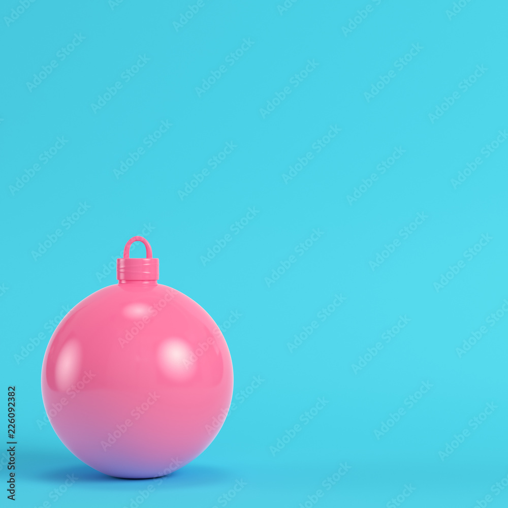 Pink christmas ball on bright blue background in pastel colors