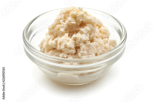 Photo Grated horseradish sauce in small glass bowl, close-up, isolated on white background