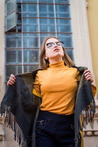 Street portrait of young beautiful woman wearing stylish vintage clothes. Model looking up. Female fashion concept. Emotions, people, beauty and lifestyle concept. Cute teenage girl. photo