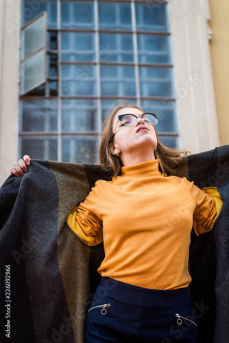 Street portrait of young beautiful woman wearing stylish vintage clothes. Model looking up. Female fashion concept. Emotions, people, beauty and lifestyle concept. Cute teenage girl. photo