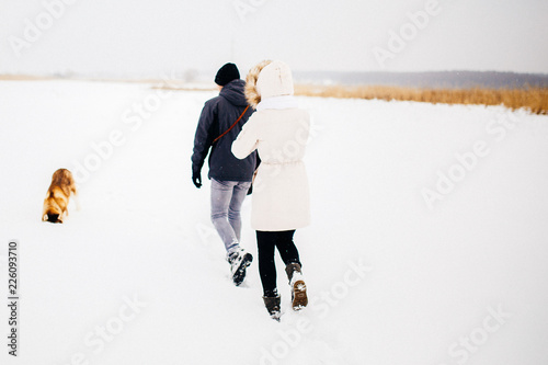 A young couple walking in the forest with the dog red husky. Toned photo