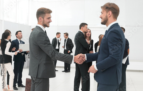 handshake of business partners on the background of business team