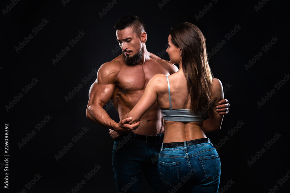 Fitness couple on a black background are in the studio