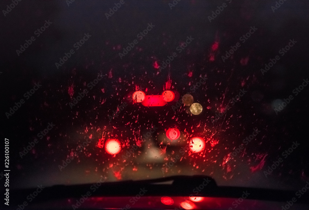 Car windshield with blood drops. Accident car crash on road. Careless driving. Car collision. Car crash night. Lights on black background. Soft focus. Car windshield with blood drops. Accident car crash on road. Careless driving. Car collision. Car crash night. Lights on black background. Soft focus.