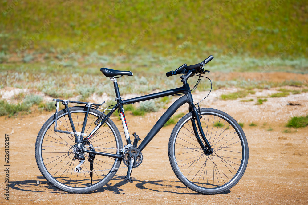 closeup black touristic bicycle among a prairie