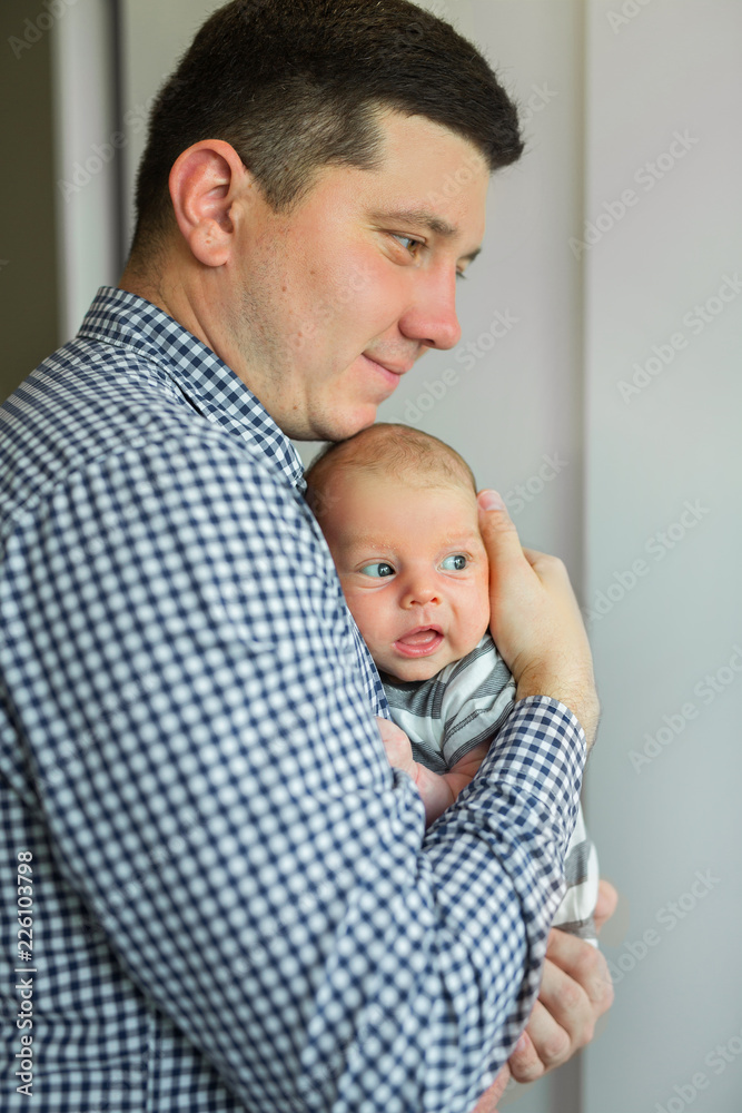 handsome young dad holds his little son in his arms handsome young dad holds his little son in his arms