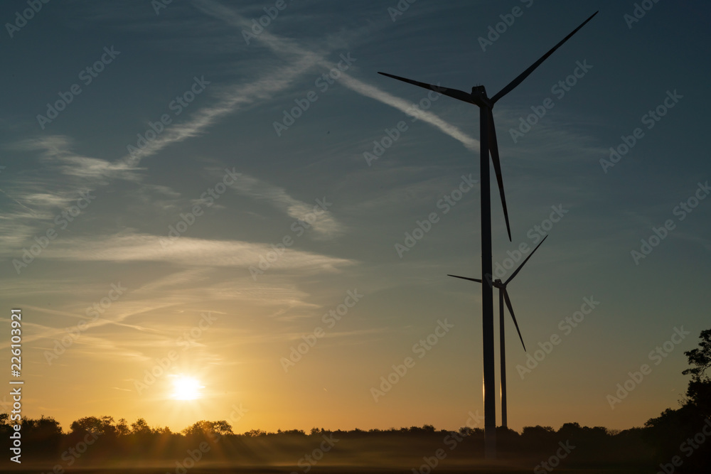Windräder bei Sonnenaufgang mit Bodennebel