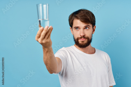 man with a glass of water on a blue background