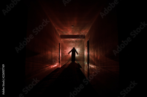 Creepy silhouette in the dark abandoned building. Dark corridor with cabinet doors and lights with silhouette of spooky horror person standing with different poses. © zef art