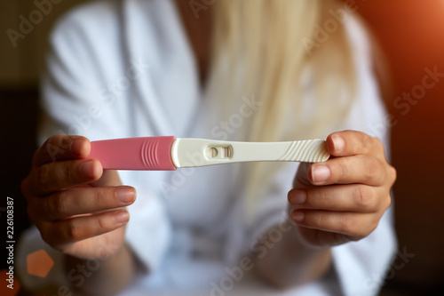 Close up of woman hand holding a positive home pregnancy test