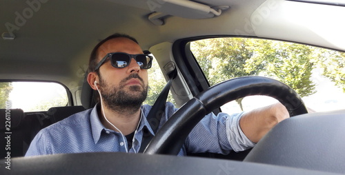 Uomo alla guida dell'auto - telefonata con auricolari  © Alfons Photographer