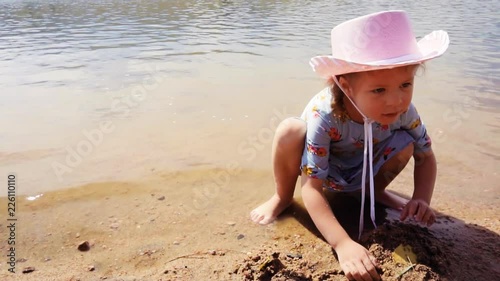 Slow motion. Little girls playing on small beach at Chatfield state park photo