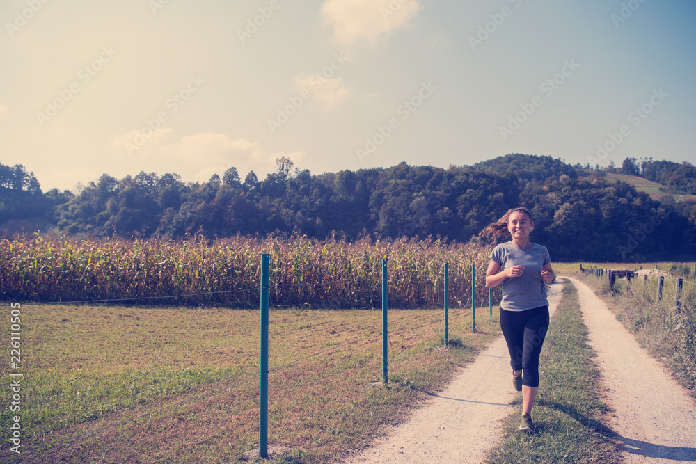 woman jogging along a country road woman jogging along a country road
