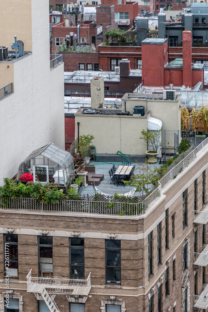 Roof garden on top of a city building. It has plants, lounging furniture,  equipment and a green house. Tops of other building can be seen Stock Photo  | Adobe Stock