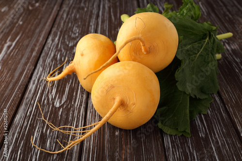 Foto Yellow turnip on wooden background.