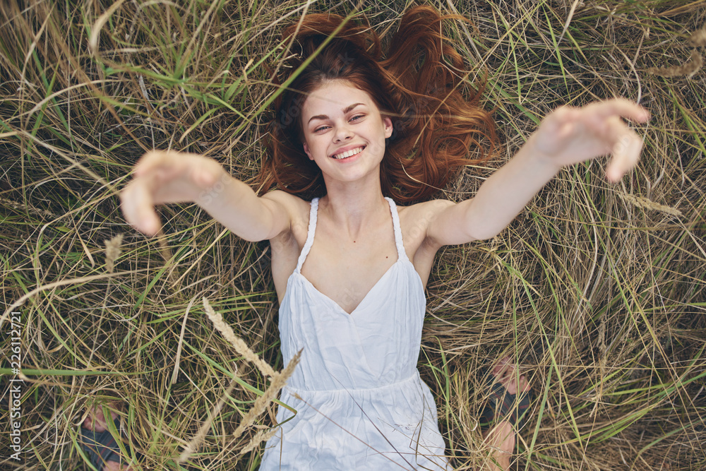 woman smiling with arms extended grass nature woman smiling with arms extended grass nature